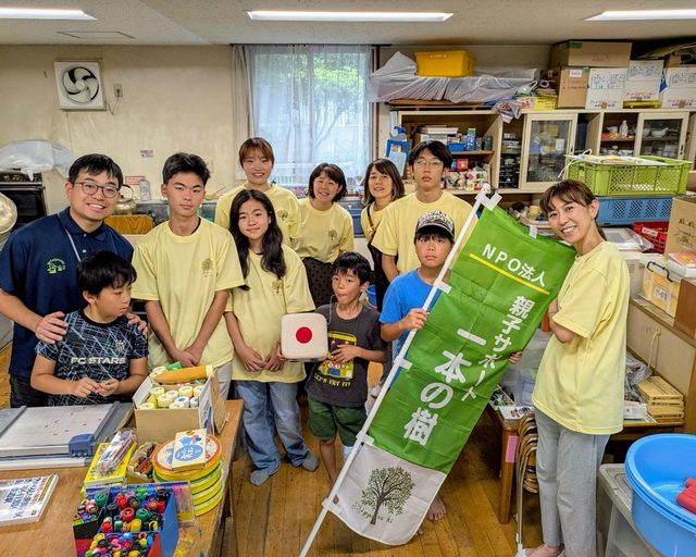 一本の樹ののぼりを持って集まった、みんなの樹のスタッフと子どもたち